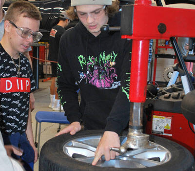 Students repairing a tire in automotive class