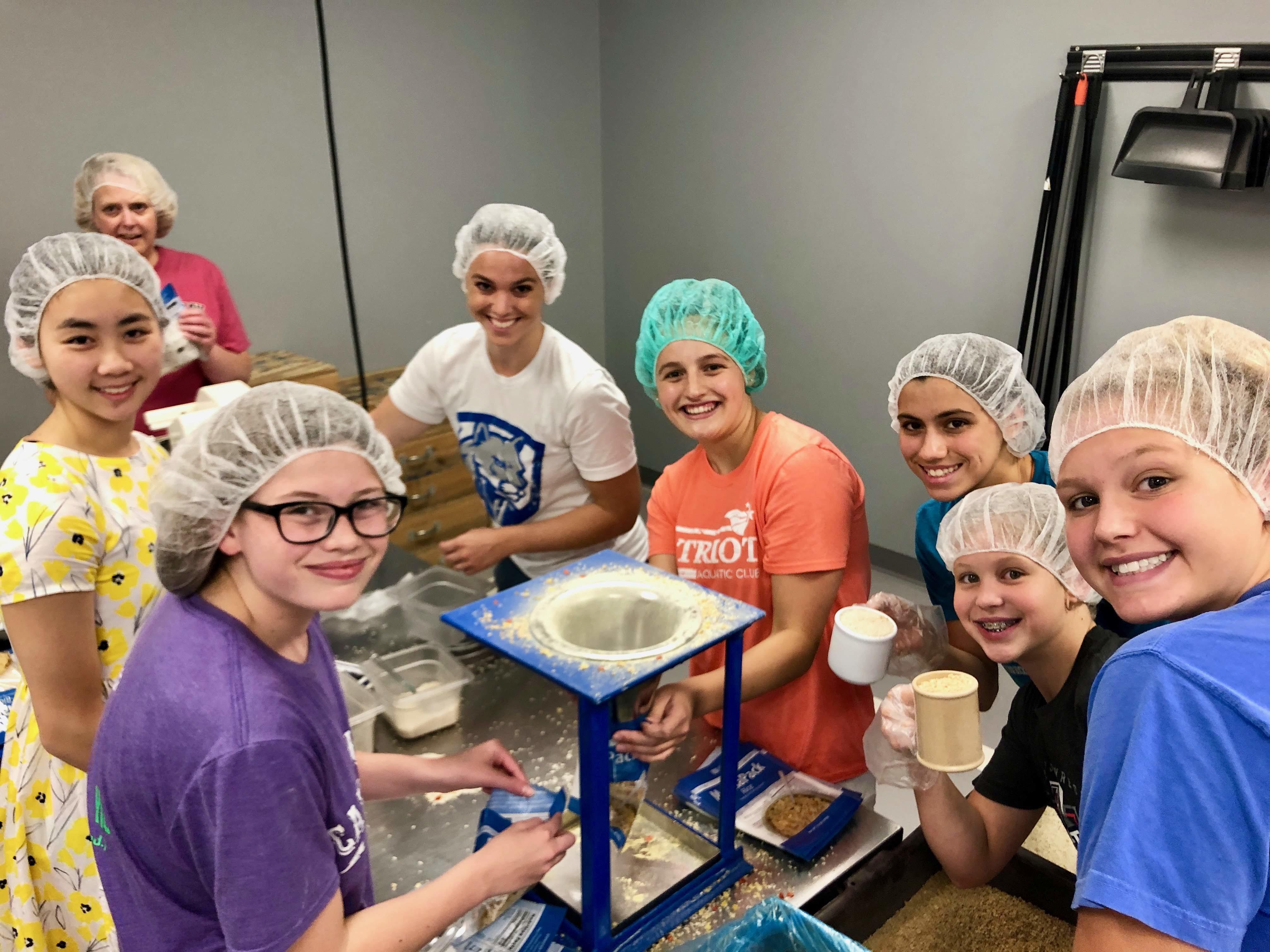 Swimmers Volunteering at Feed My Starving Children - Photo 3